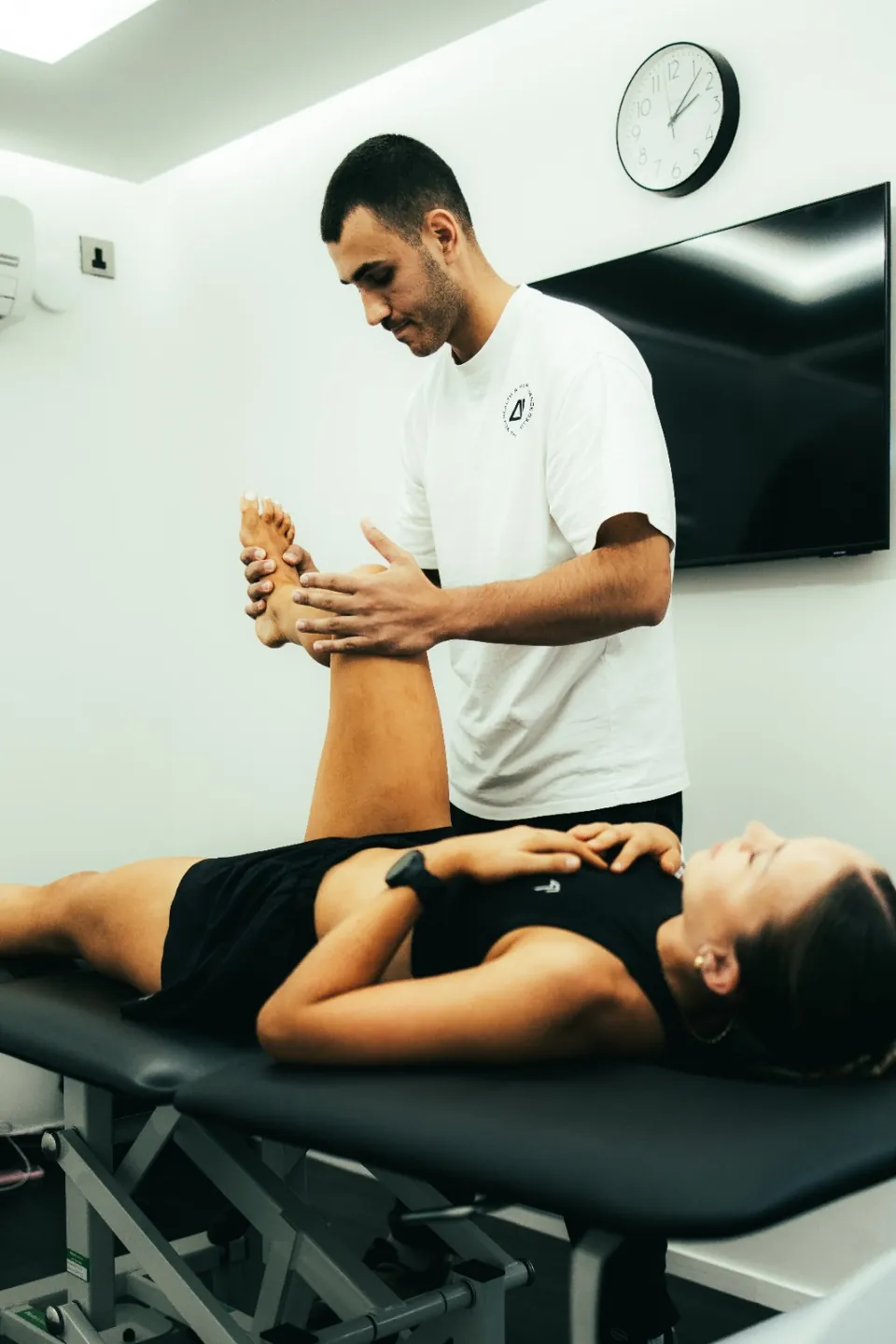 DVOTION coach guiding a client’s leg position during a table assessment