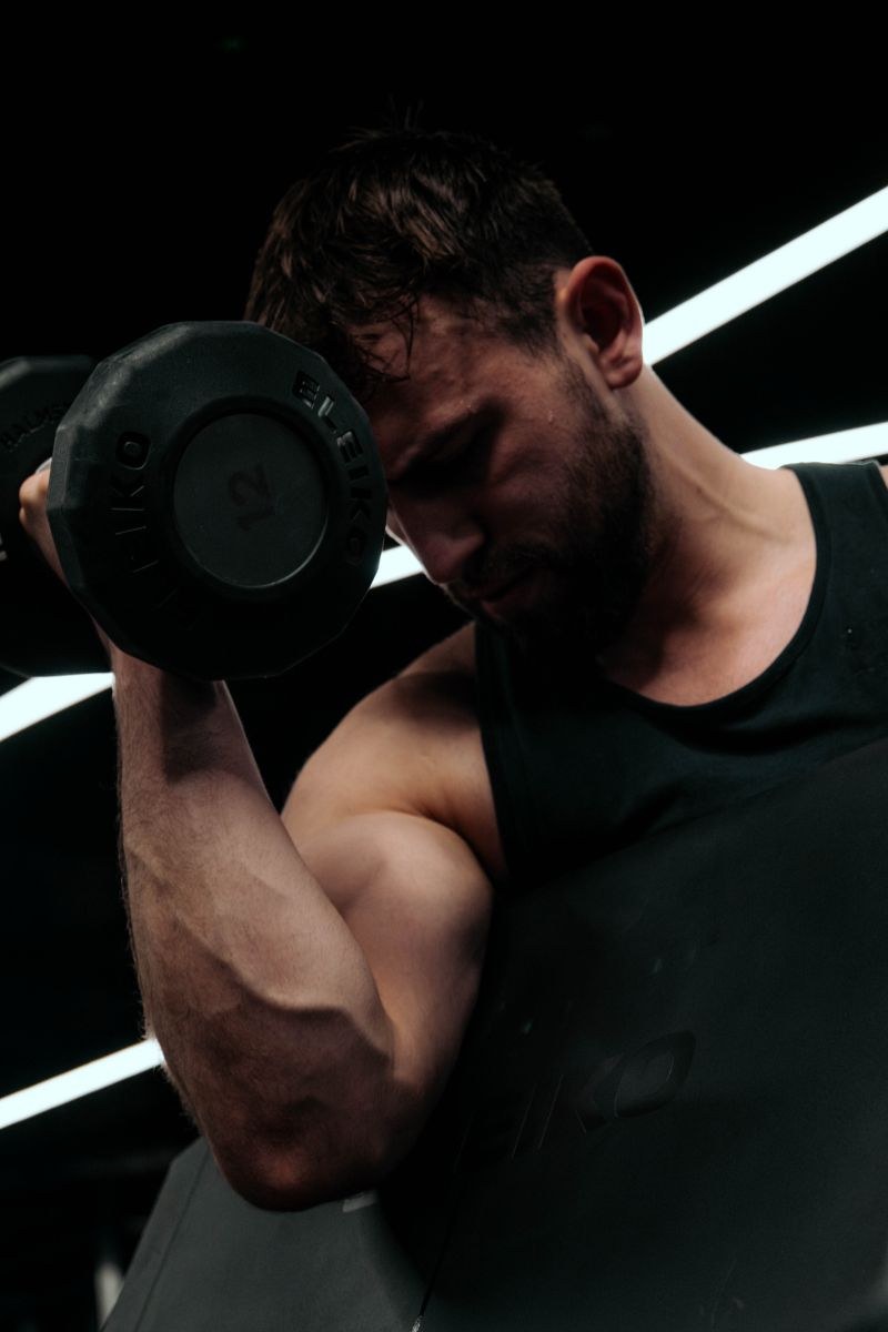 Rohan Forbes-Oneil, Performance Coach at DVOTION Labs, performing a dumbbell biceps curl