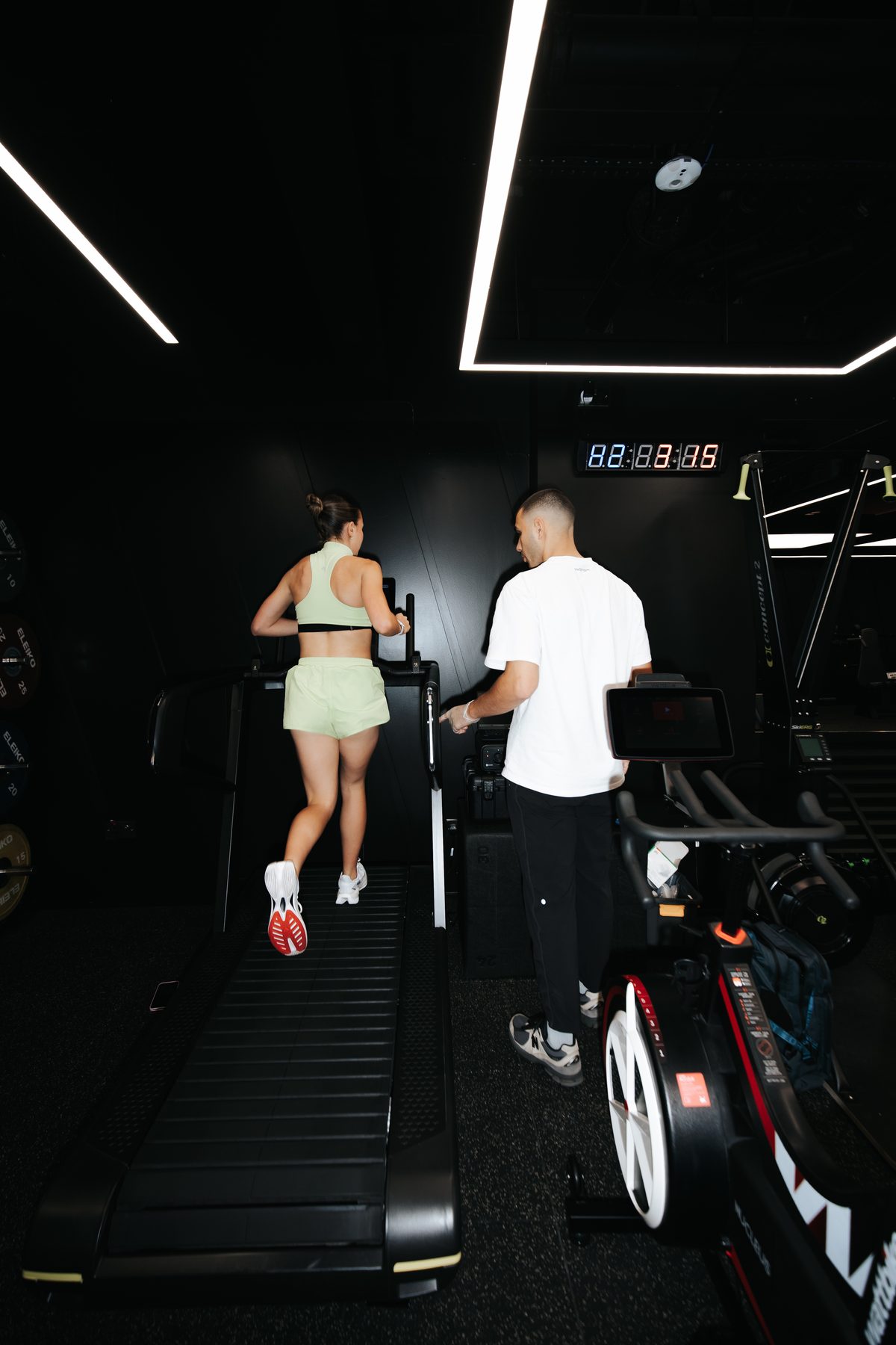 Coach beside an athlete running on the treadmill at DVOTION Labs London